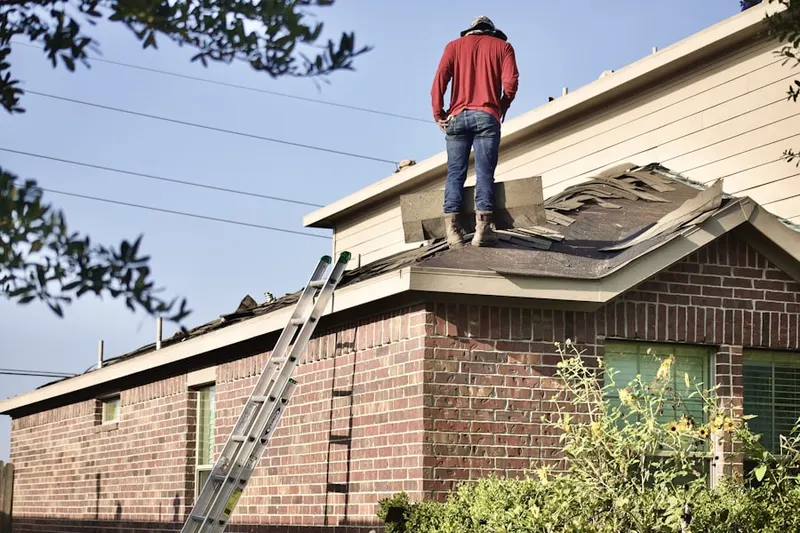 Professional roofer working on a residential roof in Iola